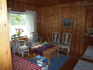 sala de estar con sillas blancas, mesa y ventana en Holiday Home Raanumaja iii by Interhome, en Lampsijärvi