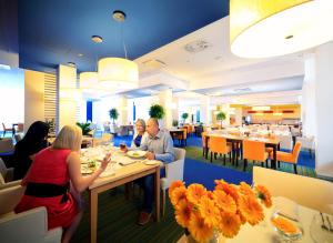 a group of people sitting at tables in a restaurant at Słoneczny Zdrój Medical Spa & Wellness in Busko-Zdrój