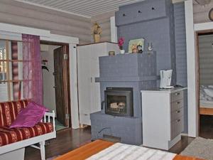 a living room with a fireplace and a couch at Holiday Home Tarvastupa by Interhome in Kemijärvi