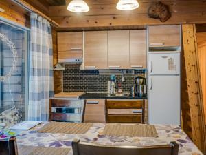 a kitchen with wooden cabinets and a white refrigerator at Holiday Home Neljä vuodenaikaa a1-karpalo by Interhome in Ylläsjärvi +14 photos