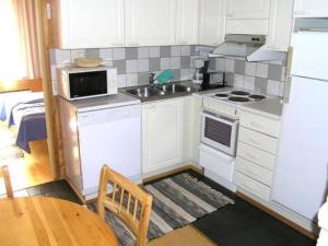 ユッラスヤルヴィにあるHoliday Home Tunturinvieri l2 by Interhomeのキッチン(白い家電製品、木製テーブル付)