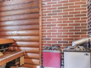 um quarto com uma parede de tijolos e uma lata de lixo vermelha em Holiday Home Karhuntuuli by Interhome em Luosto