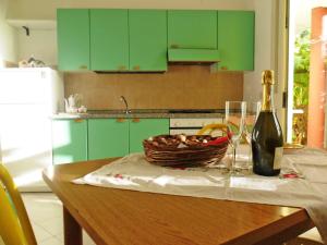 a table with a bottle of wine and a basket of food at Apartment Jacopo-2 by Interhome in Santa Maria