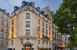 a large white building in front of a building at Hôtel le Derby Alma by Inwood Hotels in Paris