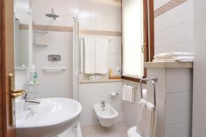 a white bathroom with a sink and a toilet at A.A.A. Armonie B&B in Mantova
