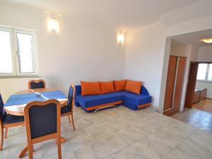 a living room with a blue couch and a table at Apartment Golub-2 by Interhome in Cesarica