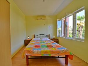 a bedroom with a bed and two windows at Holiday Home Franjo-2 by Interhome in Ika