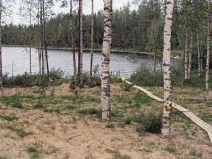 een veld met bomen en een waterlichaam bij Holiday Home 6332 by Interhome in Rantakylä