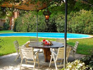 a table and chairs under an umbrella next to a pool at Villa Barchessa Palladio by Interhome in Levada