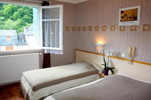 Cette chambre comprend 2 lits et une fenêtre. dans l'établissement Hotel Restaurant des Deux Vallées, à Entraygues-sur-Truyère