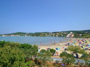 a beach with a bunch of people in the water at Apartment Lucija-2 by Interhome in Kampor