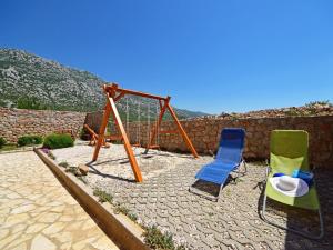 a playground with two chairs and a swing at Apartment Golub-2 by Interhome in Cesarica