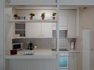 a white kitchen with white cabinets and a microwave at Apartment Blumenweg 2 by Interhome in Engelberg
