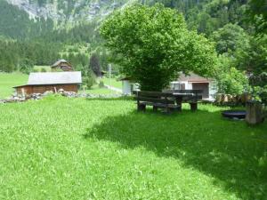 a park bench in the middle of a field with a tree at Apartment Chalet Heureka-Horbis by Interhome in Engelberg