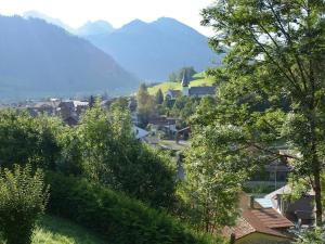 a small town with trees and mountains in the background at Apartment Hübeli - Arm by Interhome in Zweisimmen