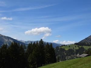 einen grünen Hügel mit Bäumen und einem blauen Himmel in der Unterkunft Apartment Alphütte Gibelhüttli by Interhome in Giebel