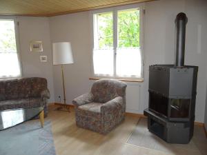 uma sala de estar com uma cadeira e um fogão em Apartment Blackenmattli by Interhome em Engelberg
