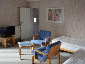 um quarto com duas cadeiras e uma cama e uma televisão em Apartment Arlette Nr- 30 by Interhome em Gstaad