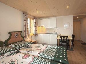 1 Schlafzimmer mit 2 Betten, einem Tisch und einer Küche in der Unterkunft Apartment Mutthorn by Interhome in Lauenen
