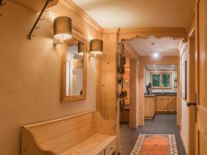 einen Flur mit einer Holzbank und einem Spiegel in der Unterkunft Apartment Les Silenes by Interhome in Gstaad