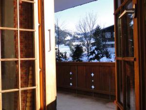 Une porte ouverte s'ouvre sur un balcon avec vue. dans l'établissement Apartment Zapfe - Moore by Interhome, à Saanenmöser