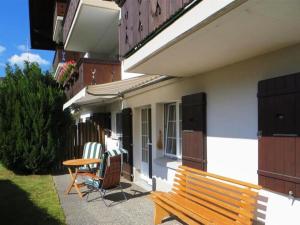 a wooden bench sitting outside of a house at Apartment Fink by Interhome in Zweisimmen