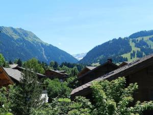 Blick auf ein Dorf mit Bergen im Hintergrund in der Unterkunft Apartment Im Wiesengrund by Interhome in Gstaad