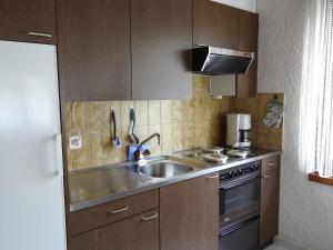 a kitchen with a sink and a stove at Apartment Birkenstrasse 70-2 by Interhome in Engelberg