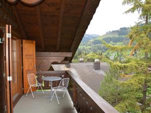 porche de una cabaña con sillas y mesa en Apartment Hornflue - Wohlwender by Interhome, en Gstaad
