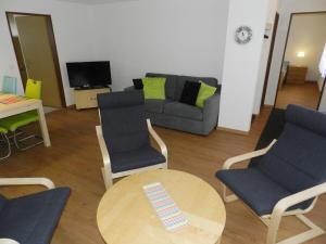 ein Wohnzimmer mit einem Sofa, einem Tisch und Stühlen in der Unterkunft Apartment Diana by Interhome in Gstaad