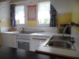 uma cozinha com um lavatório, um fogão e janelas em Apartment Steinacher by Interhome em Engelberg
