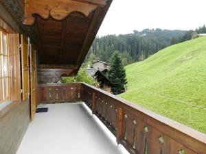 a balcony of a house with a view of a hill at Apartment Hornflue - Baumann by Interhome in Gstaad