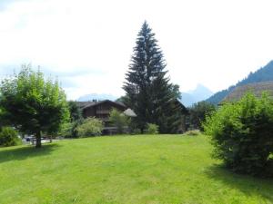 een groot groen veld met bomen en een huis bij Apartment Monique Nr- 14 by Interhome in Gstaad