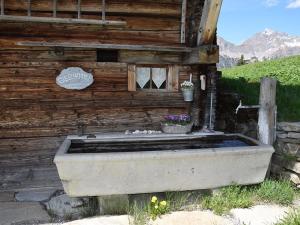 eine Badewanne außerhalb eines Holzgebäudes in der Unterkunft Apartment Alphütte Gibelhüttli by Interhome in Giebel