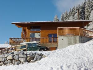 ein Haus mit einem grünen Truck im Schnee in der Unterkunft Apartment Nubes- Chalet by Interhome in Zweisimmen