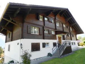 a large wooden house with stairs on the side at Apartment Fink by Interhome in Zweisimmen