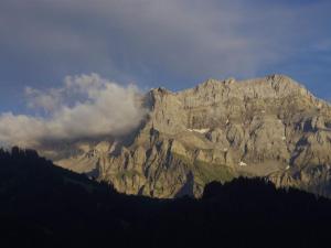 a large rocky mountain with clouds in the sky at Apartment Anno Domini by Interhome in Adelboden