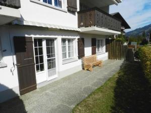 a white house with a bench in front of it at Apartment Fink by Interhome in Zweisimmen