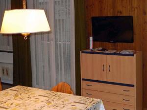 a table with a lamp and a television on a dresser at Apartment Sörenweg 4 by Interhome in Engelberg