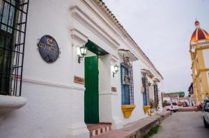a building with a green door and a clock on it at Casa Faccioli in Mompos