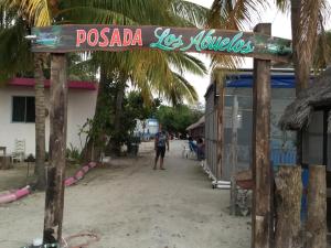 a sign for a resort on the beach at Posada los abuelos in Holbox Island
