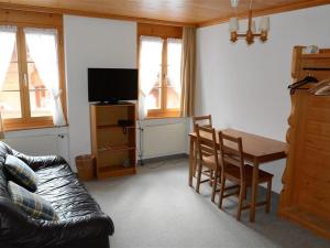 een woonkamer met een tafel en een bank bij Apartment Mireille Nr- 3 by Interhome in Gstaad