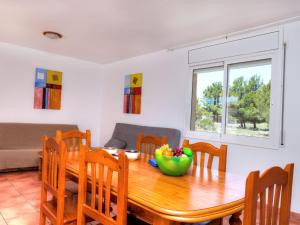 a dining room table with a bowl of fruit on it at Villa Villa Mimosa I by Interhome in Les tres Cales