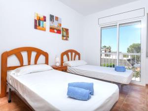 two beds in a room with a window at Holiday Home Villa Santa Marta I by Interhome in Les tres Cales