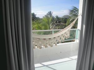 a view from a window of a balcony with palm trees at Pousada Lessence By Solarium in São Miguel do Gostoso