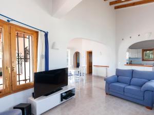 a living room with a blue couch and a tv at Villa Jillian by Interhome in Monte Pego