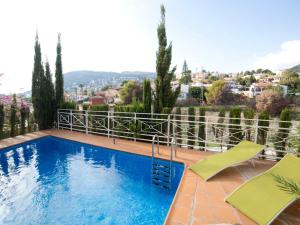 a swimming pool with chairs and a view of a city at Holiday Home Junio by Interhome in Calpe