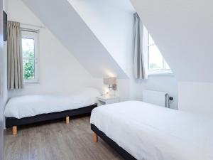 duas camas num quarto com duas janelas em Holiday Home de Witte Raaf by Interhome em Noordwijk