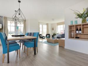een eetkamer en woonkamer met een tafel en stoelen bij Holiday Home Tapuit 8-1 by Interhome in Noordwijk