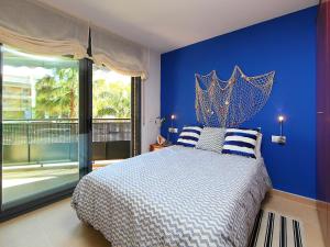 a blue bedroom with a bed with a blue wall at Apartment Can Pavet by Interhome in Vilafortuny